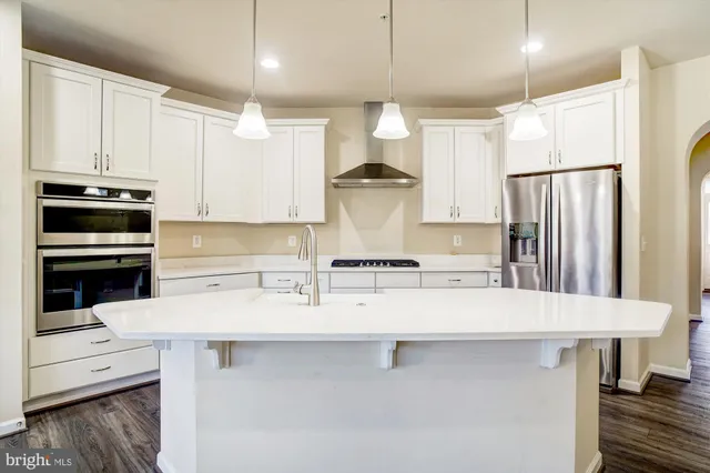 a kitchen with stainless steel appliances a refrigerator and a stove top oven