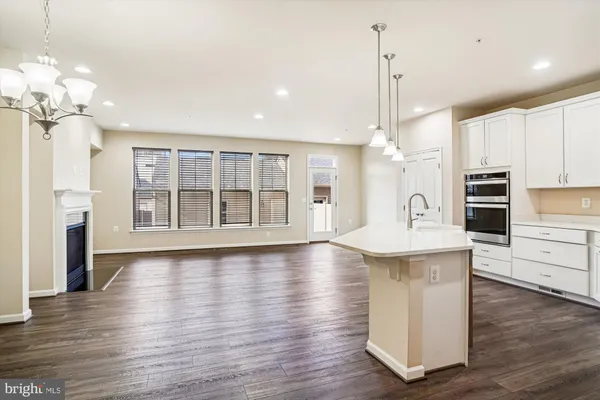 a kitchen with stainless steel appliances granite countertop a sink a stove and a wooden floors