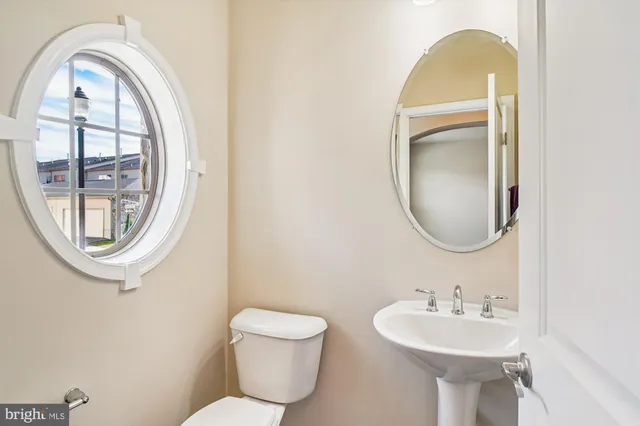 a bathroom with a toilet a sink and a mirror