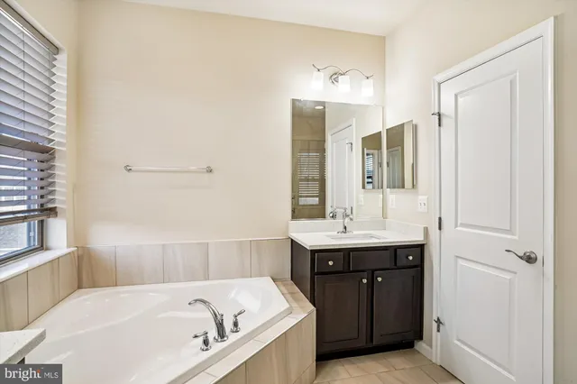 a bathroom with a bathtub and double sink