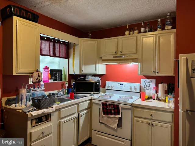 a kitchen with stainless steel appliances a stove refrigerator sink and cabinets