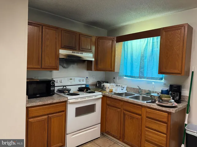 a kitchen with stainless steel appliances granite countertop wooden cabinets a stove a sink and dishwasher