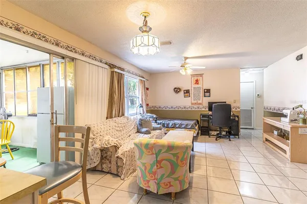 a living room with furniture a dining table and a chandelier