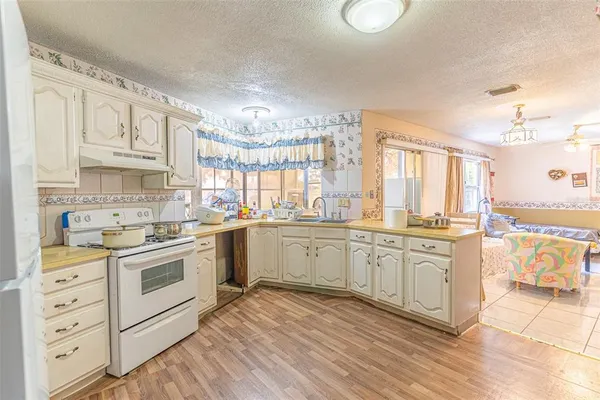 a kitchen with granite countertop white cabinets and white appliances