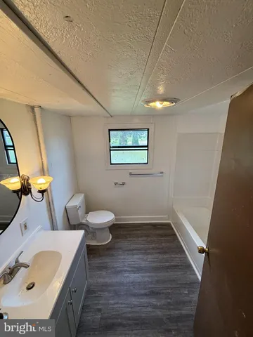 a bathroom with a sink mirror vanity and toilet
