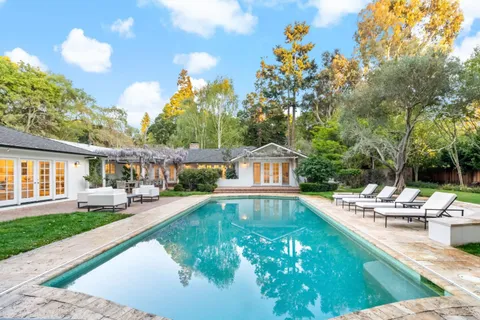 a view of a house with swimming pool and sitting area
