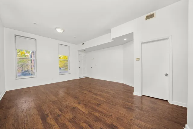 a view of empty room with window and wooden floor