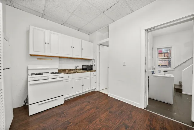 a kitchen with granite countertop white cabinets and white appliances
