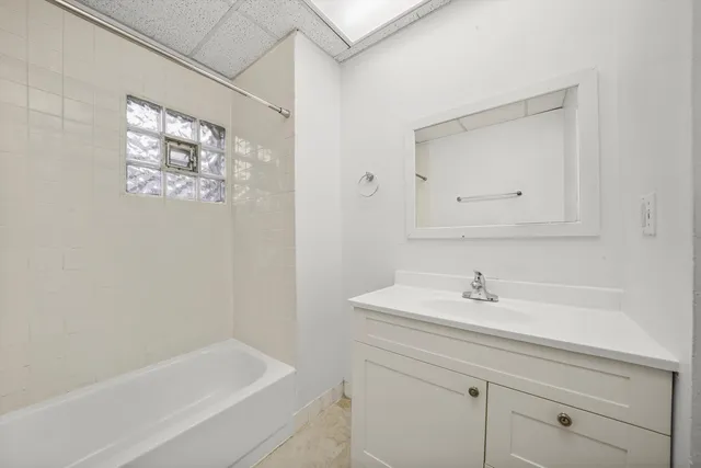 a bathroom with a bathtub a sink and a window