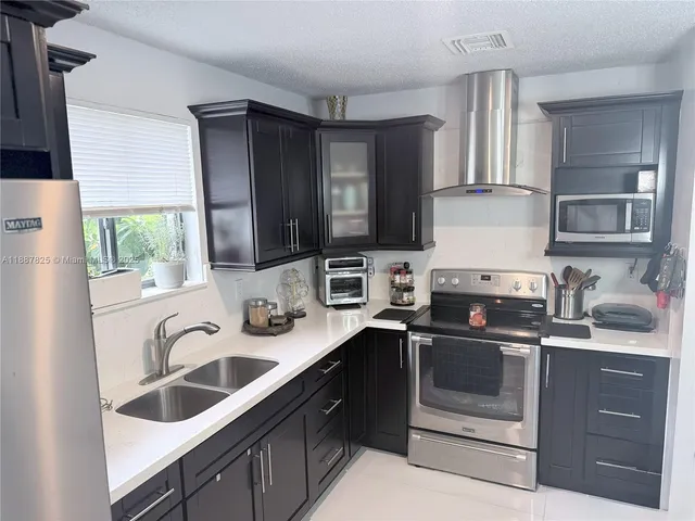 a kitchen with stainless steel appliances granite countertop a sink stove and microwave