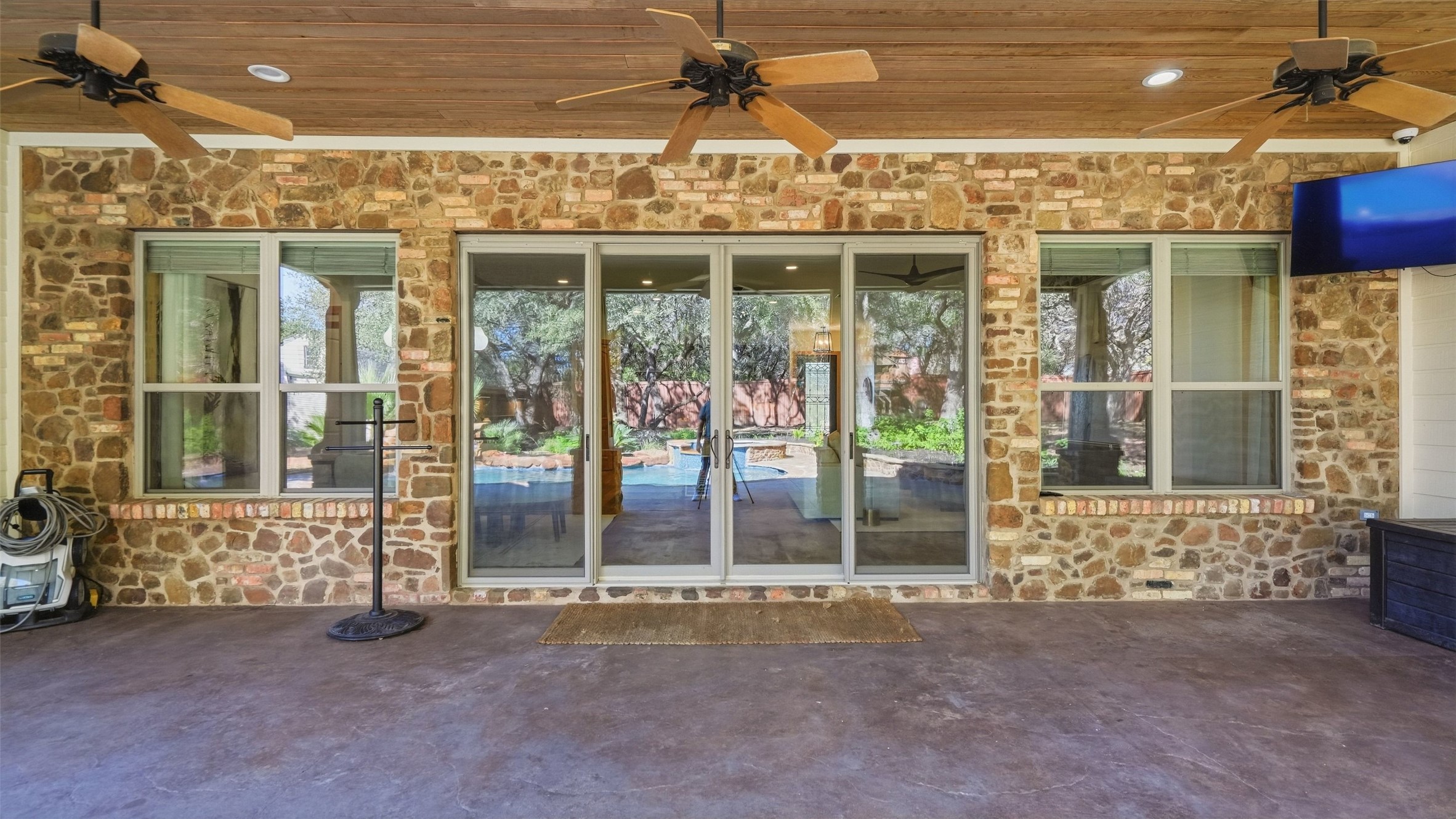 5910 Hudson Bend Road Austin, TX 78734 - Photo 32 of 40 A spacious covered patio showcases a warm wood-plank ceiling and a textured stone wall.