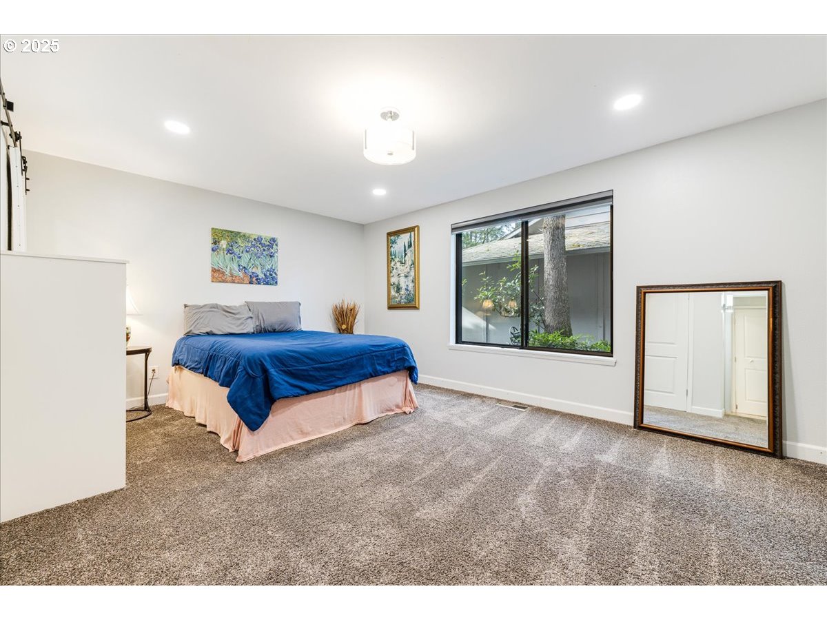 4268 Woodside Circle Lake Oswego, OR 97035 - Photo 23 of 44 a spacious bedroom with a large bed and a large window
