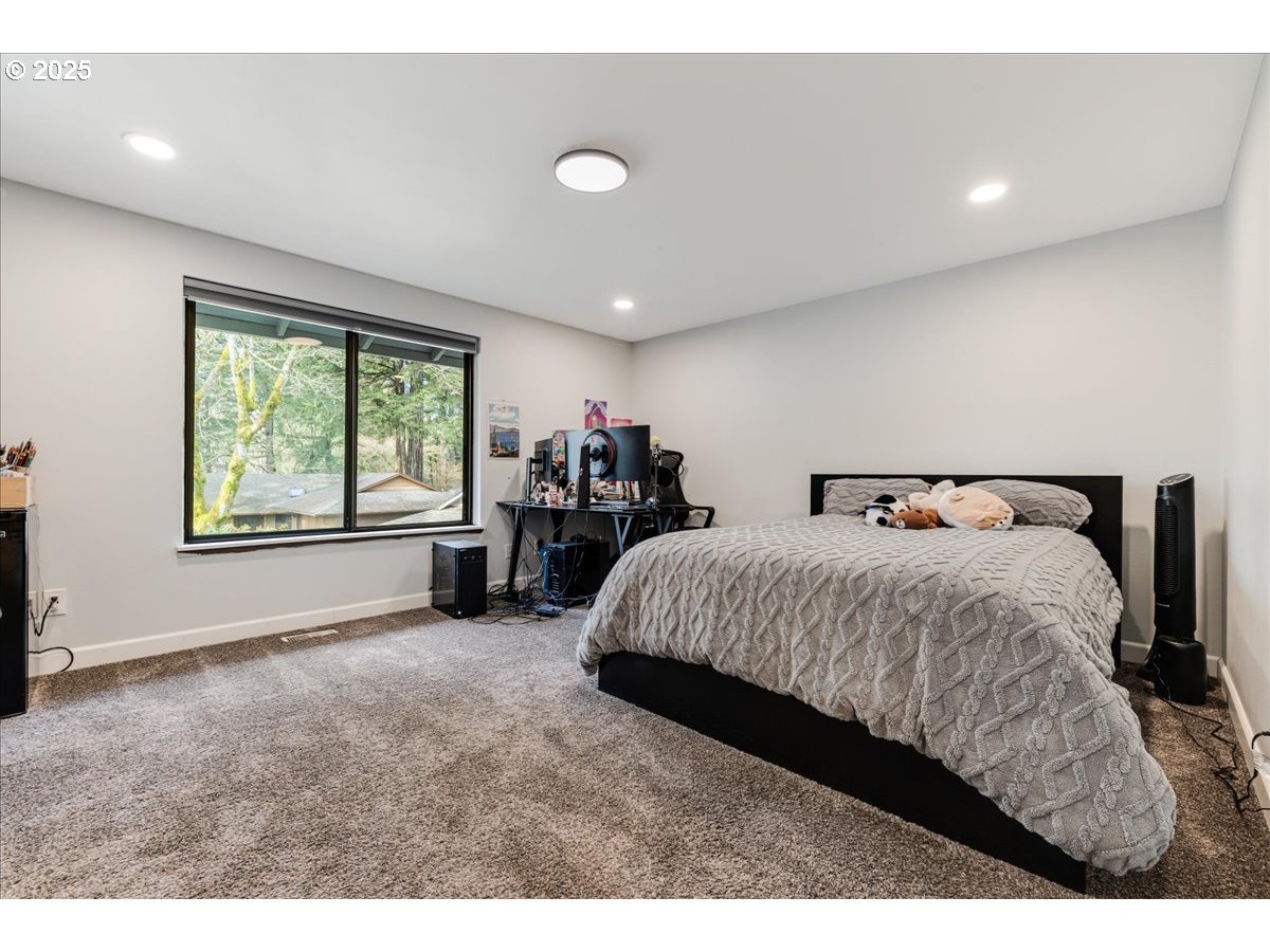 4268 Woodside Circle Lake Oswego, OR 97035 - Photo 24 of 44 a spacious bedroom with a bed and a large window