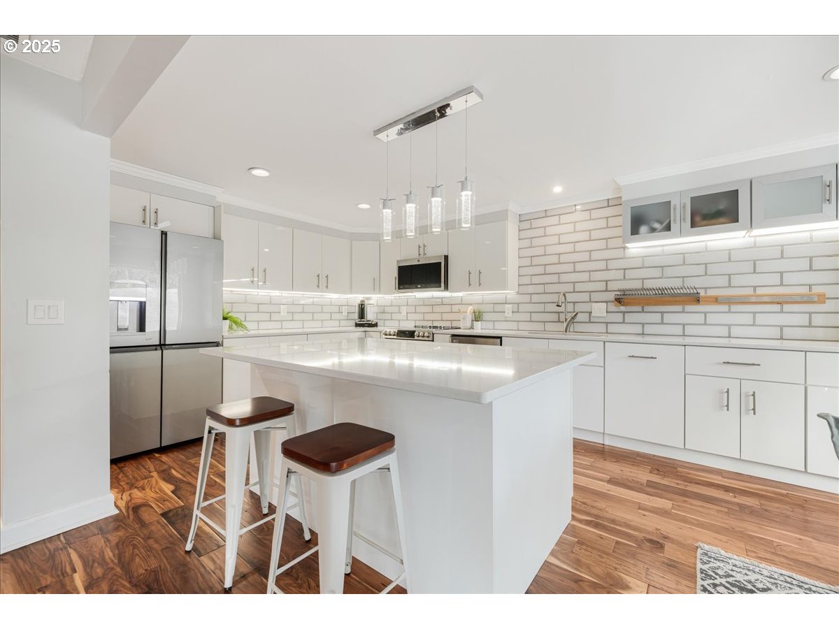 4268 Woodside Circle Lake Oswego, OR 97035 - Photo 6 of 44 a kitchen with kitchen island a sink stainless steel appliances and cabinets