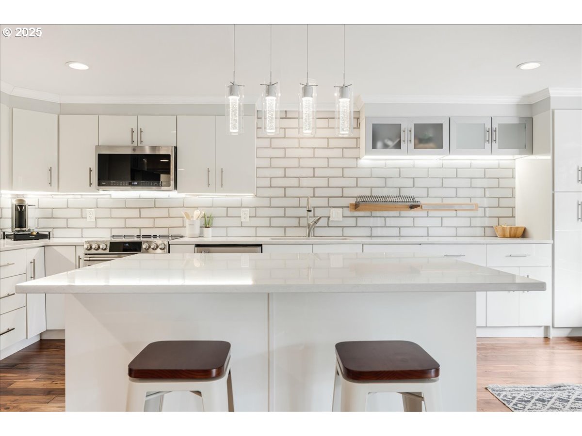 4268 Woodside Circle Lake Oswego, OR 97035 - Photo 7 of 44 a kitchen with stainless steel appliances a sink a stove and white cabinets