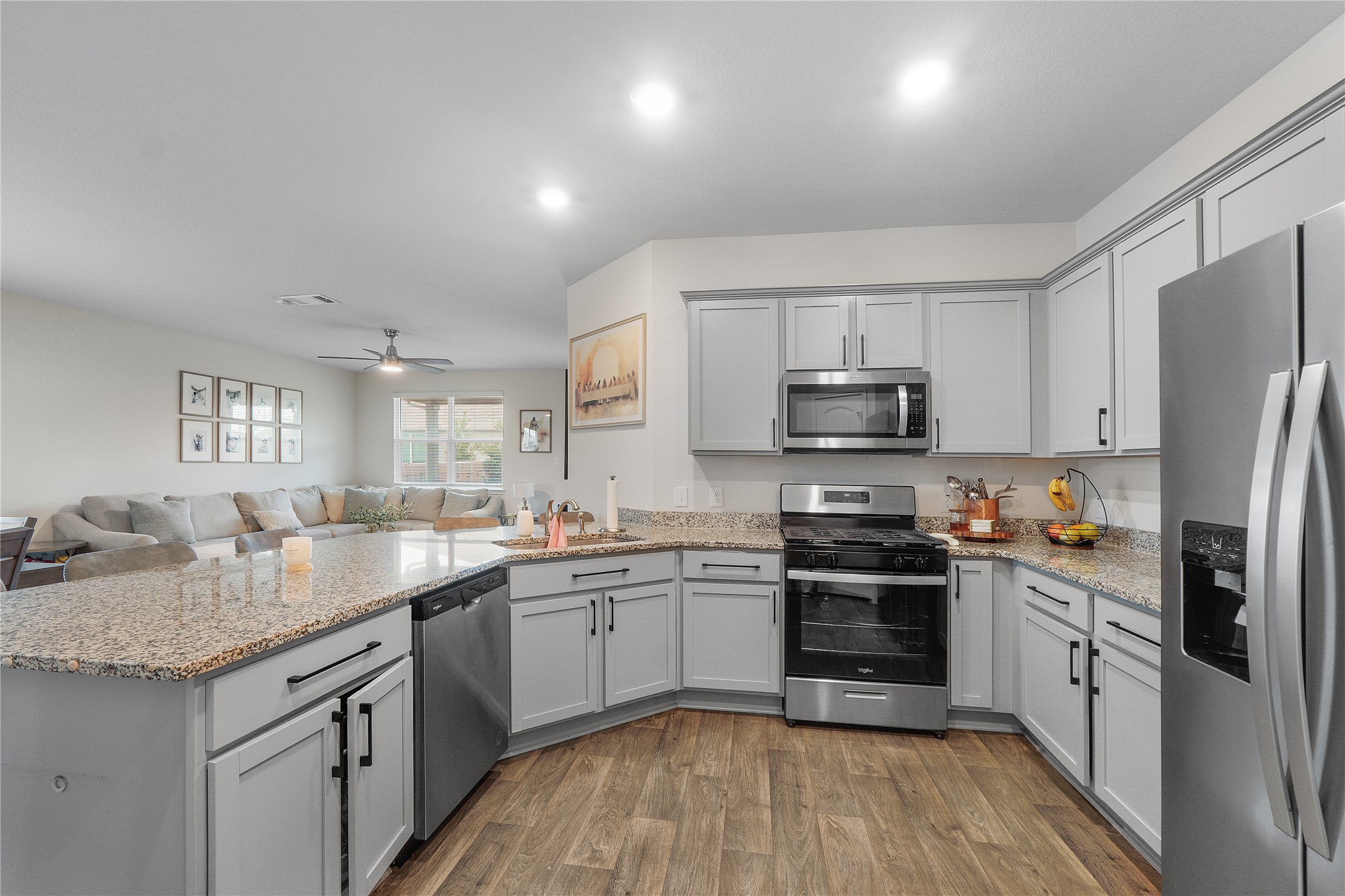 217 Evergreen Sumac Loop Kyle, TX 78640 - Photo 6 of 20 An open concept kitchen features abundant counter space and modern appliances, seamlessly connecting to a spacious living area.