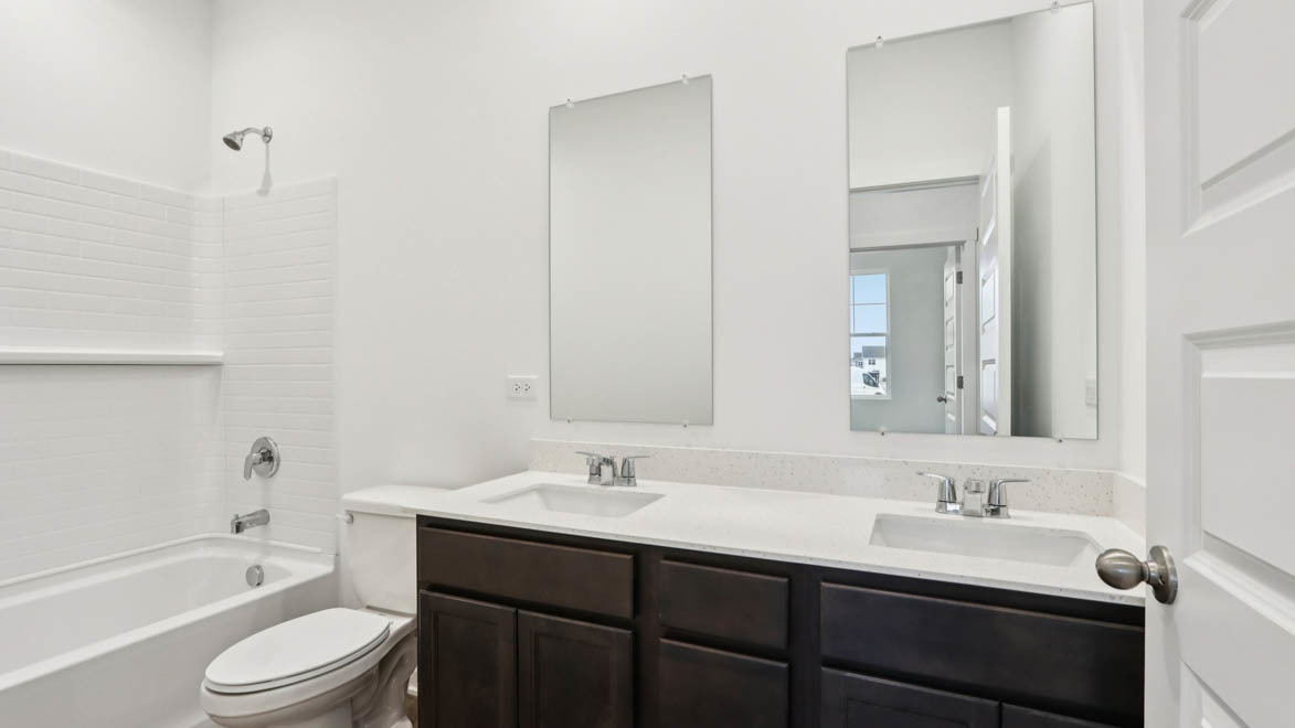 284 Snowdrop Lane Elgin, IL 60124 - Photo 13 of 33 a bathroom with a granite countertop sink toilet a large mirror a bathtub and shower