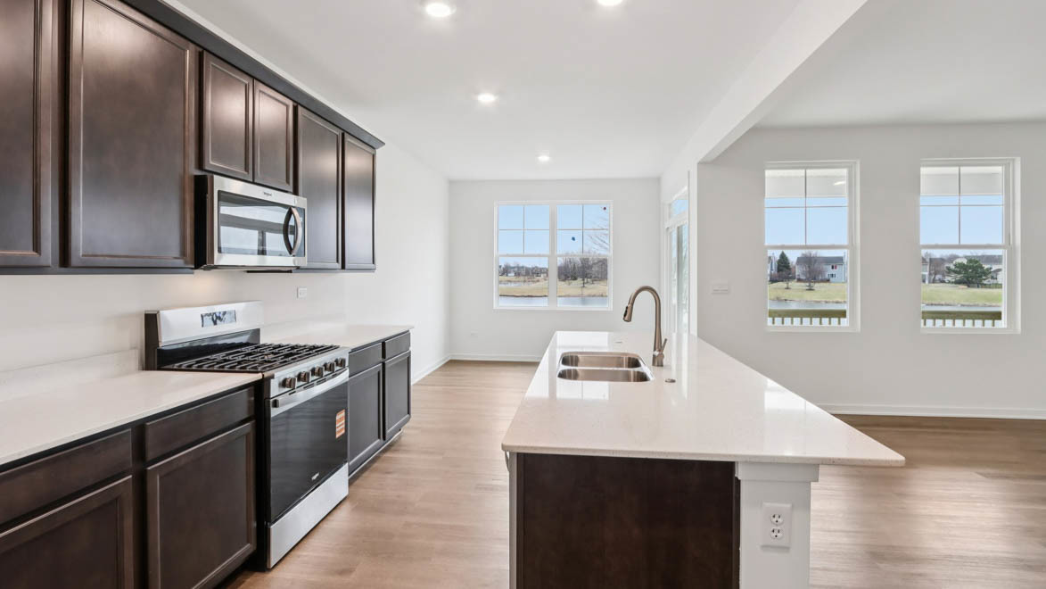 284 Snowdrop Lane Elgin, IL 60124 - Photo 6 of 33 a kitchen with stainless steel appliances a sink dishwasher stove refrigerator and wooden cabinets