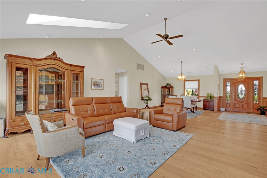 9093 Stump Point Road Hayes, VA 23072 - Photo 7 of 40 Vaulted ceiling with skylight, wood-finish flooring, recessed lighting, ceiling fan, and decorative double entry doors with oval glass inserts