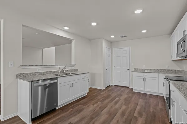 a spacious bathroom with a granite countertop sink a mirror and a toilet