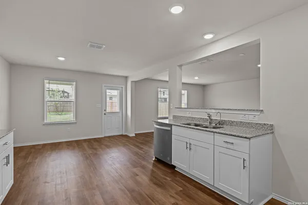 a bathroom with a granite countertop sink a mirror and a toilet