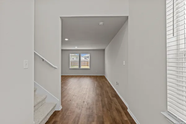 a view of a hallway with wooden floor and staircase