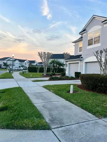 a front view of a house with a garden and parking