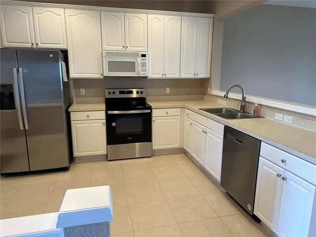 a kitchen with stainless steel appliances granite countertop a refrigerator sink and cabinets
