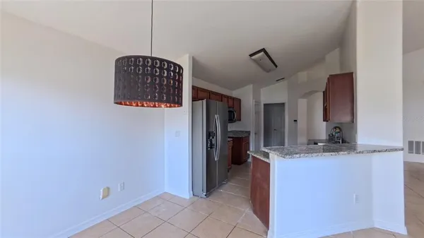 a view of kitchen with refrigerator and cabinets
