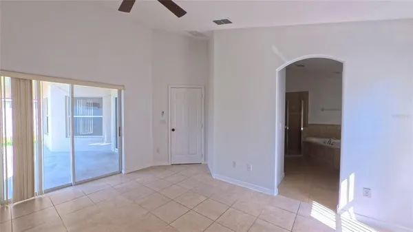 an empty room with closet and a chandelier fan