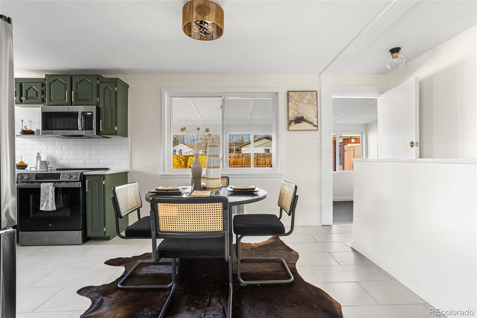 8140 Raleigh Street Westminster, CO 80031 - Photo 15 of 39 a living room with furniture a flat screen tv and kitchen view