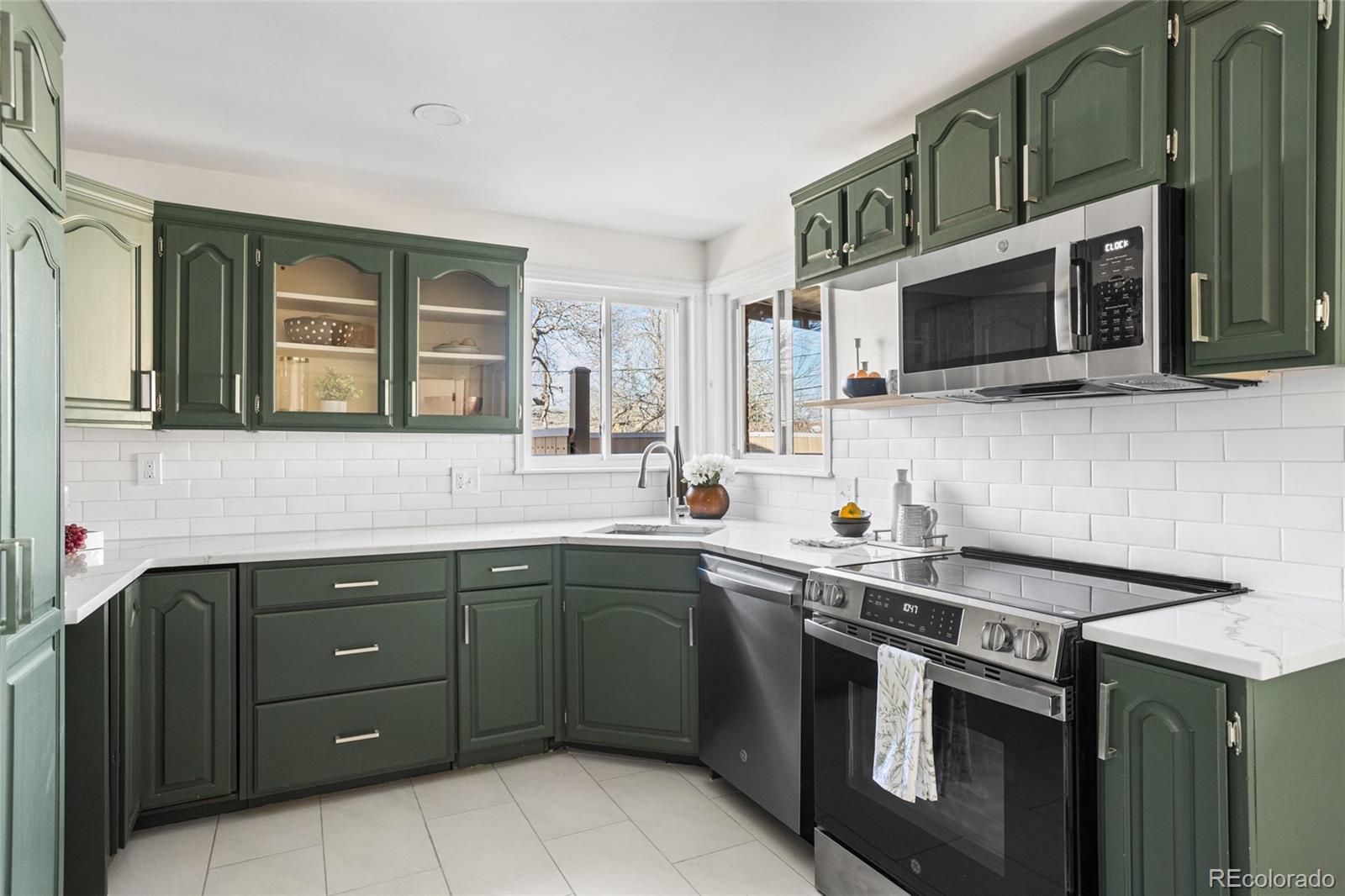 8140 Raleigh Street Westminster, CO 80031 - Photo 17 of 39 a kitchen with stainless steel appliances a sink stove and microwave