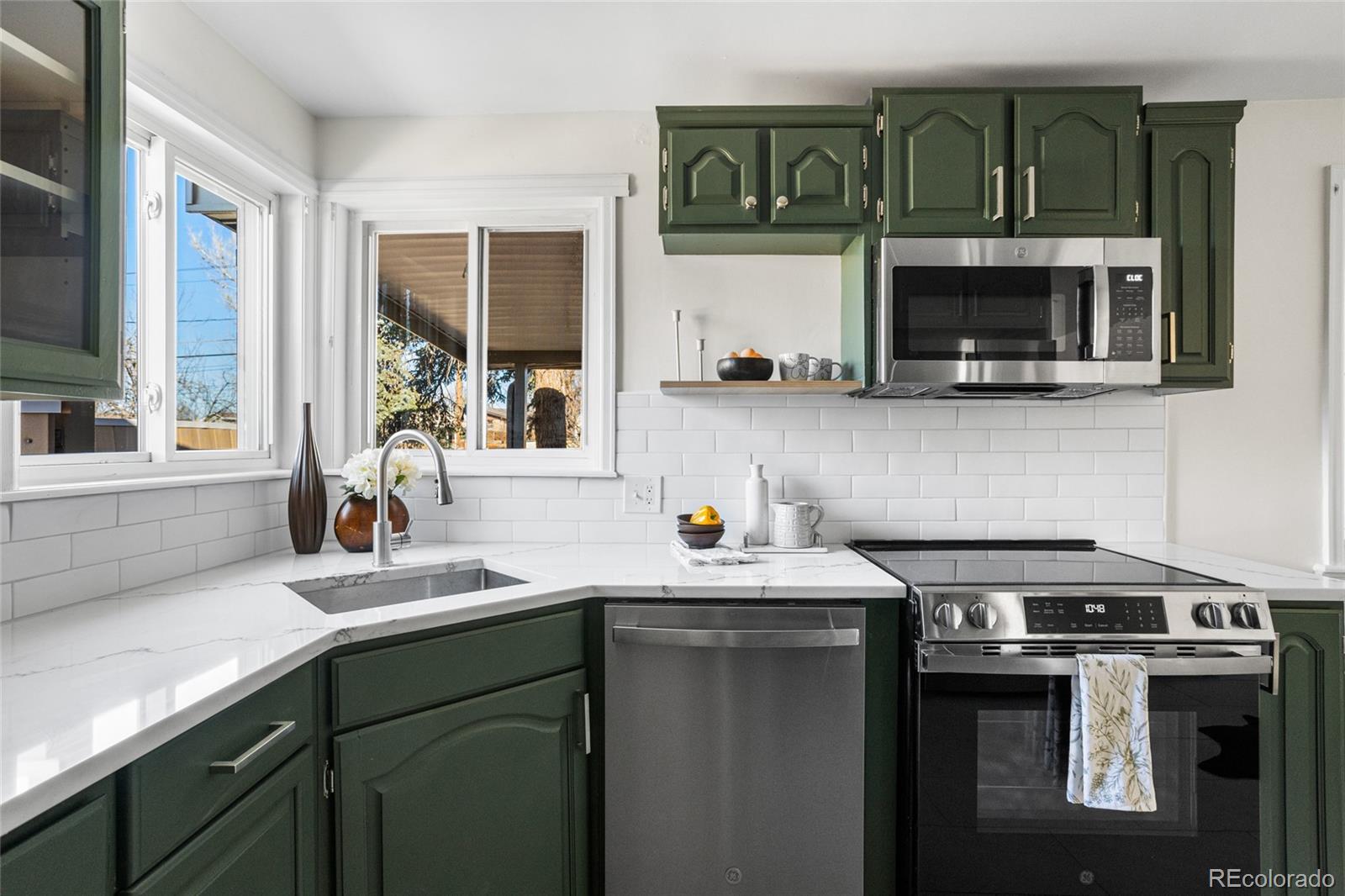 8140 Raleigh Street Westminster, CO 80031 - Photo 19 of 39 a kitchen with stainless steel appliances a sink and a microwave