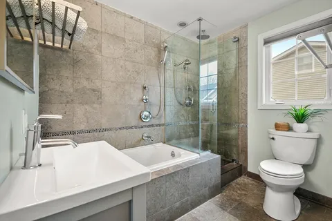 a bathroom with a sink a toilet and shower