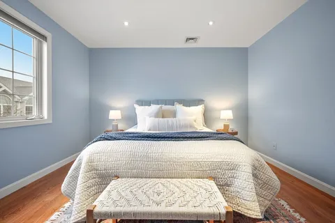 a bed sitting in a bedroom next to a window