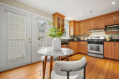 a kitchen with stainless steel appliances granite countertop a kitchen island hardwood floor and a sink