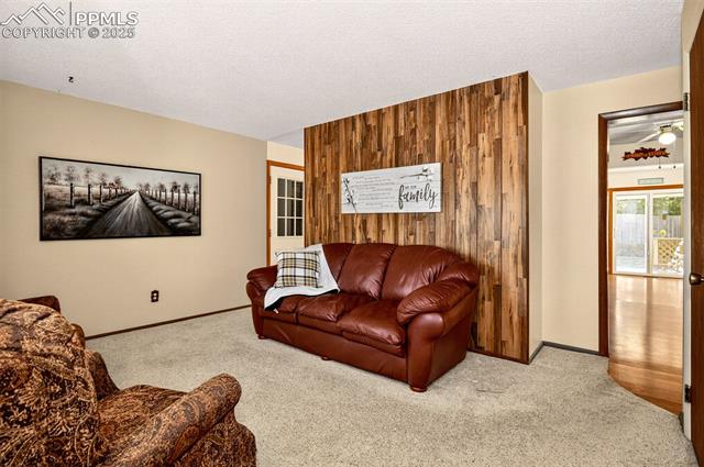 6723 Seneca Road Colorado Springs, CO 80915 - Photo 4 of 36 Wood panel accent walls and dual access to the kitchen and dining areas