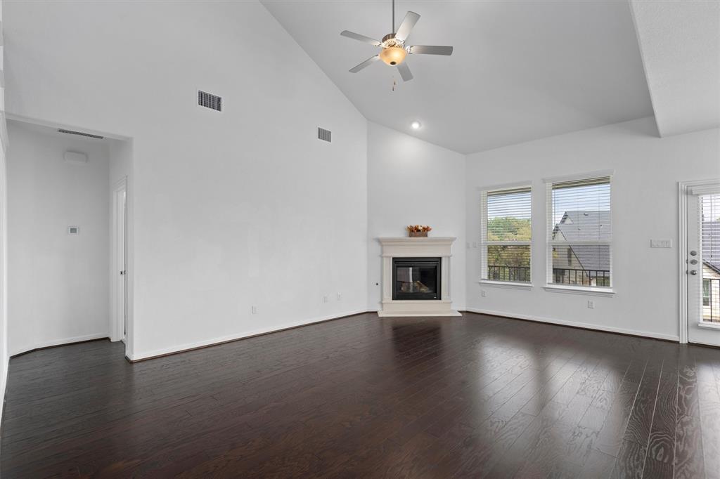 236 Prato Place Georgetown, TX 78628 - Photo 10 of 40 Vast living area featuring soaring vaulted ceilings, rich hardwood flooring, and an inviting fireplace.