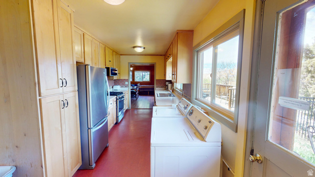 315 Abbey Road Moab, UT 84532 - Photo 19 of 46 Kitchen featuring stainless steel appliances, light countertops, washer and dryer, and light wood finish cabinetry