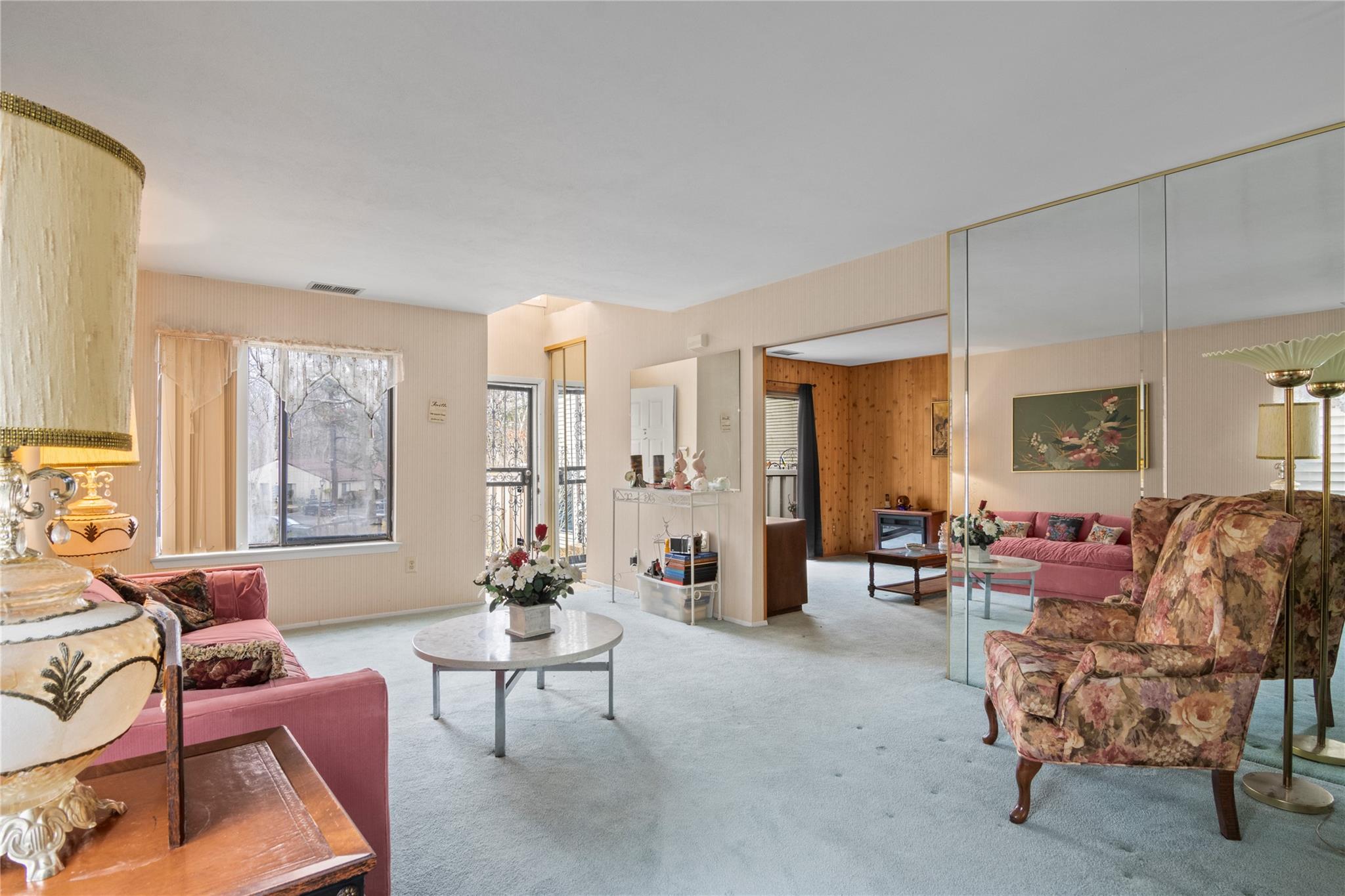 154 Birchwood Road Coram, NY 11727 - Photo 5 of 13 Living room with visible vents, wooden walls, and carpet flooring