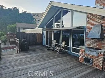 a view of a patio with table and chairs with wooden floor and fence