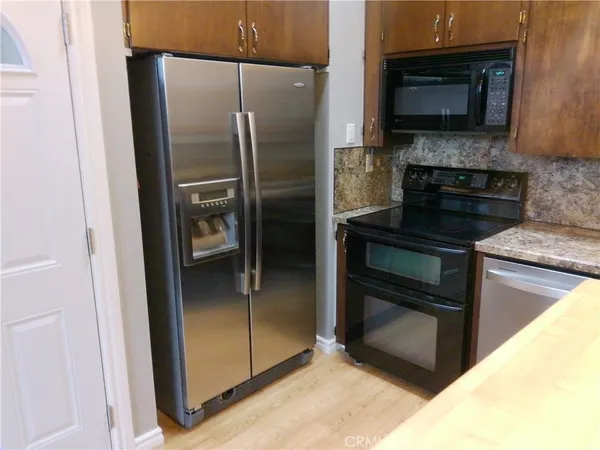 a kitchen with a refrigerator and a stove top oven