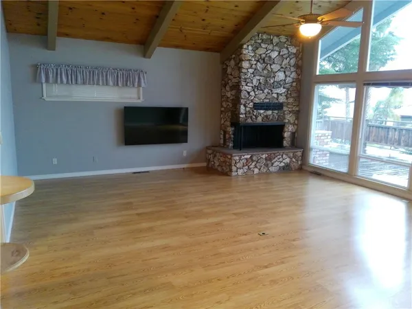 a view of an empty room with a fireplace and a window