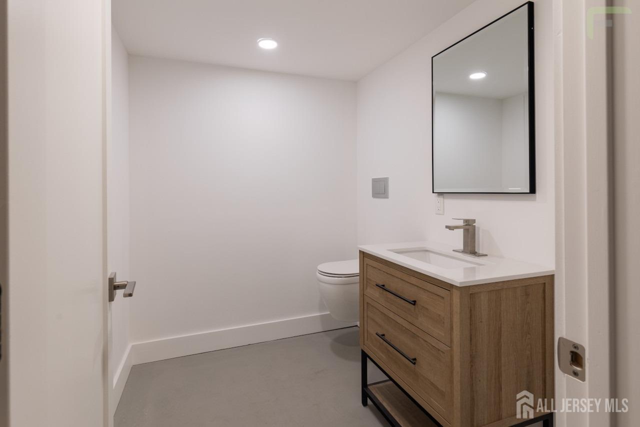 274 Paterson Road Fanwood, NJ 07023 - Photo 25 of 31 a bathroom with a granite countertop sink a toilet and a mirror