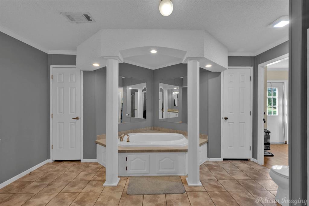 62 Princeton Lane Princeton, LA 71067 - Photo 16 of 33 Full bath with light tile patterned floors, a garden tub, ornamental molding, and a textured ceiling