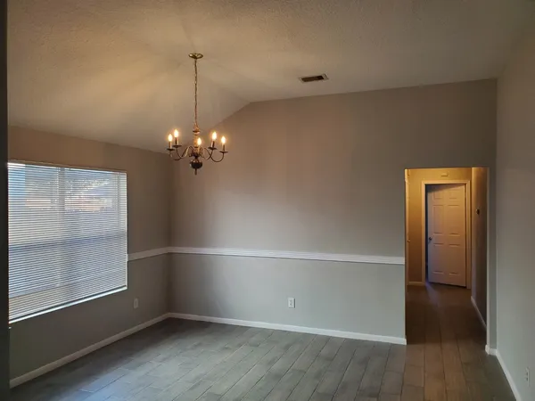 a view of a chandelier in an empty room with a window
