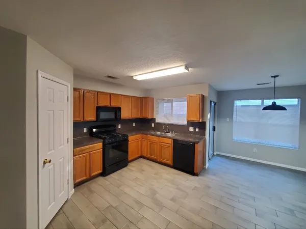 a large kitchen with a wooden floor and a stove top oven