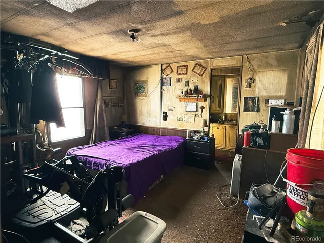 a bedroom with a bed next to a window