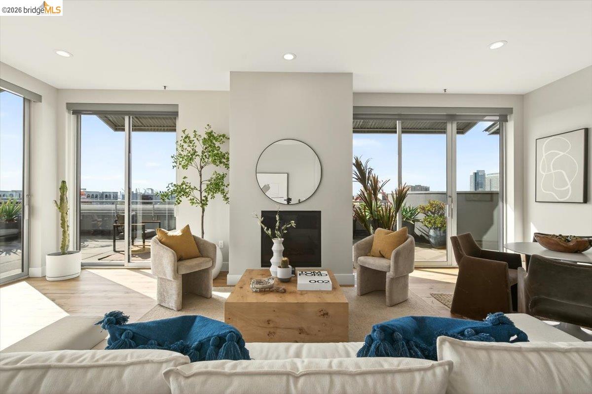 201 4th Street, Unit 601 Oakland, CA 94607 - Photo 17 of 58 a living room with furniture a fireplace and a floor to ceiling window