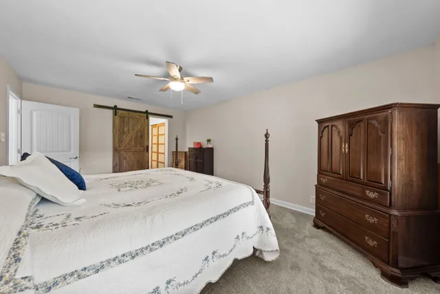a spacious bedroom with a bed and a chandelier